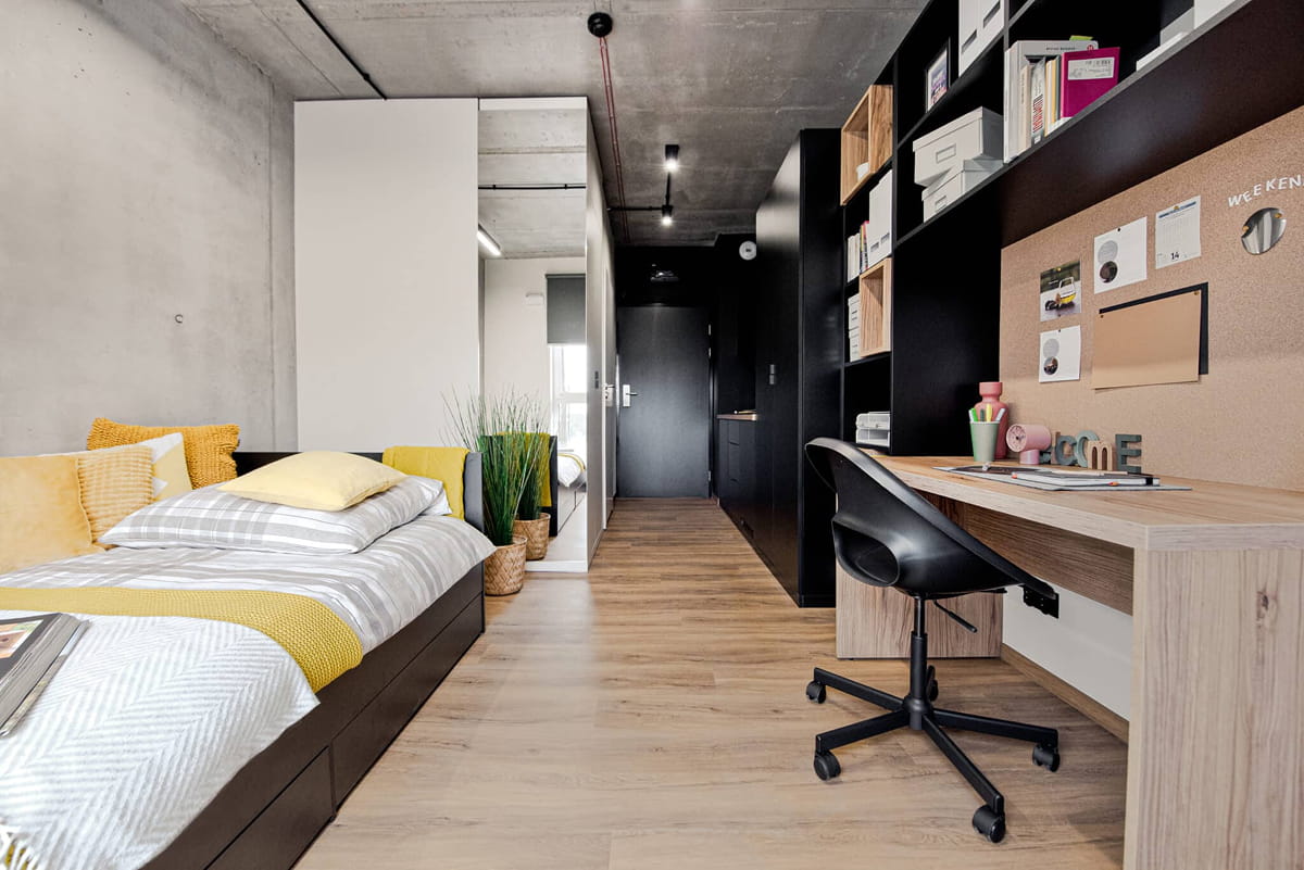 A Shed Kraków studio with a dedicated study area and built-in storage.